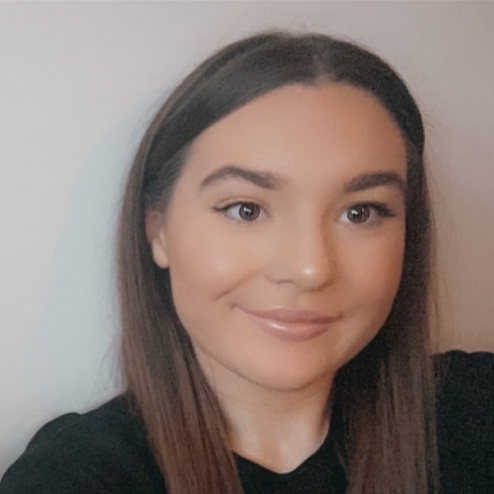 Woman smiling with straight brown hair.