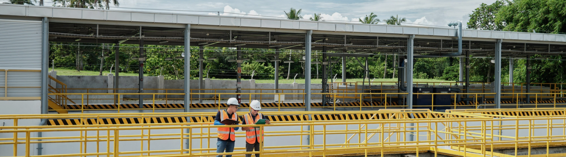 Dalawang empleyado ng Cargill na may suot na helmet at vest pangkaligtasan ang nagsusuri ng dokumento sa isang pasilidad ng produksyon sa Pilipinas.