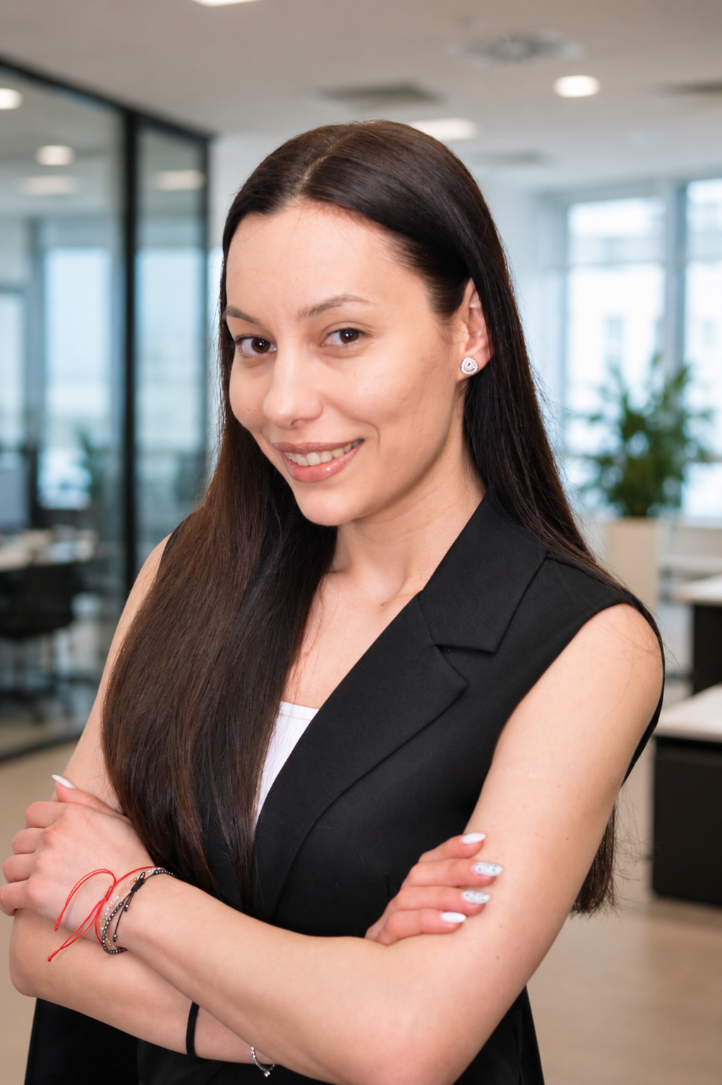 Cargill early careers professional wearing a white top and a black sleeveless blazer, photographed in a modern office environment with a blurred workspace background, representing professionalism, confidence, and early career growth opportunities.