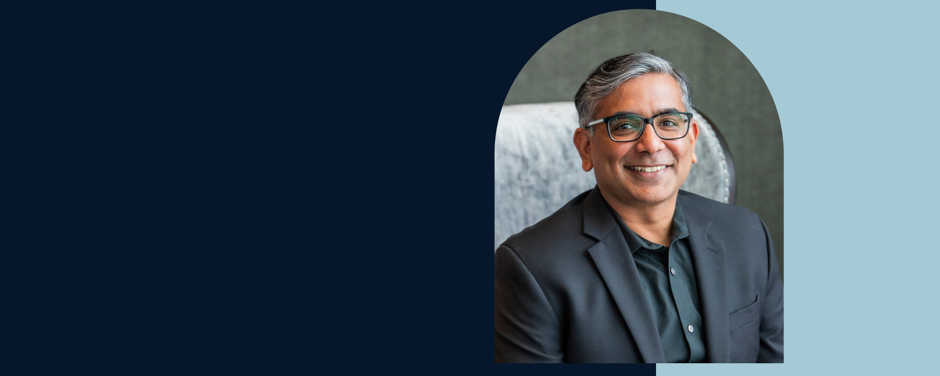 Capital One associate Arjun smiles over a two tone blue background