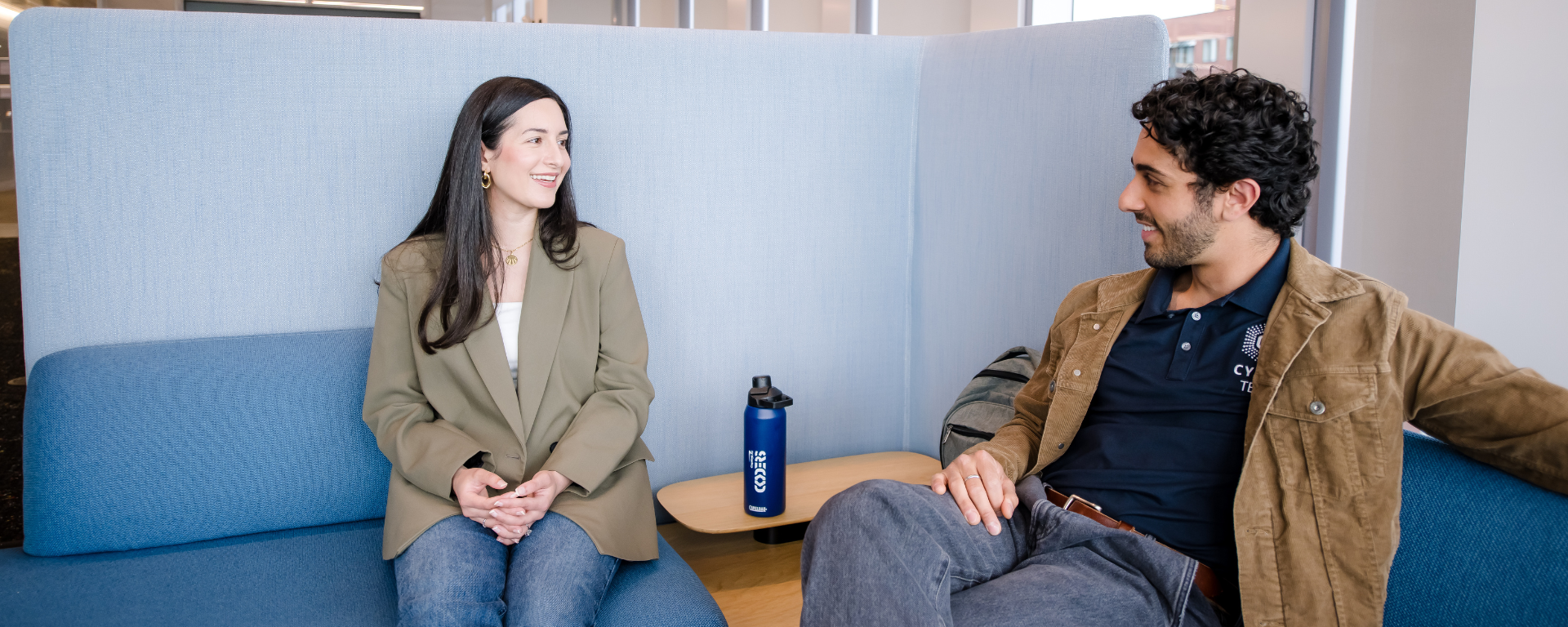 Two Capital One employees sitting on chairs and talking