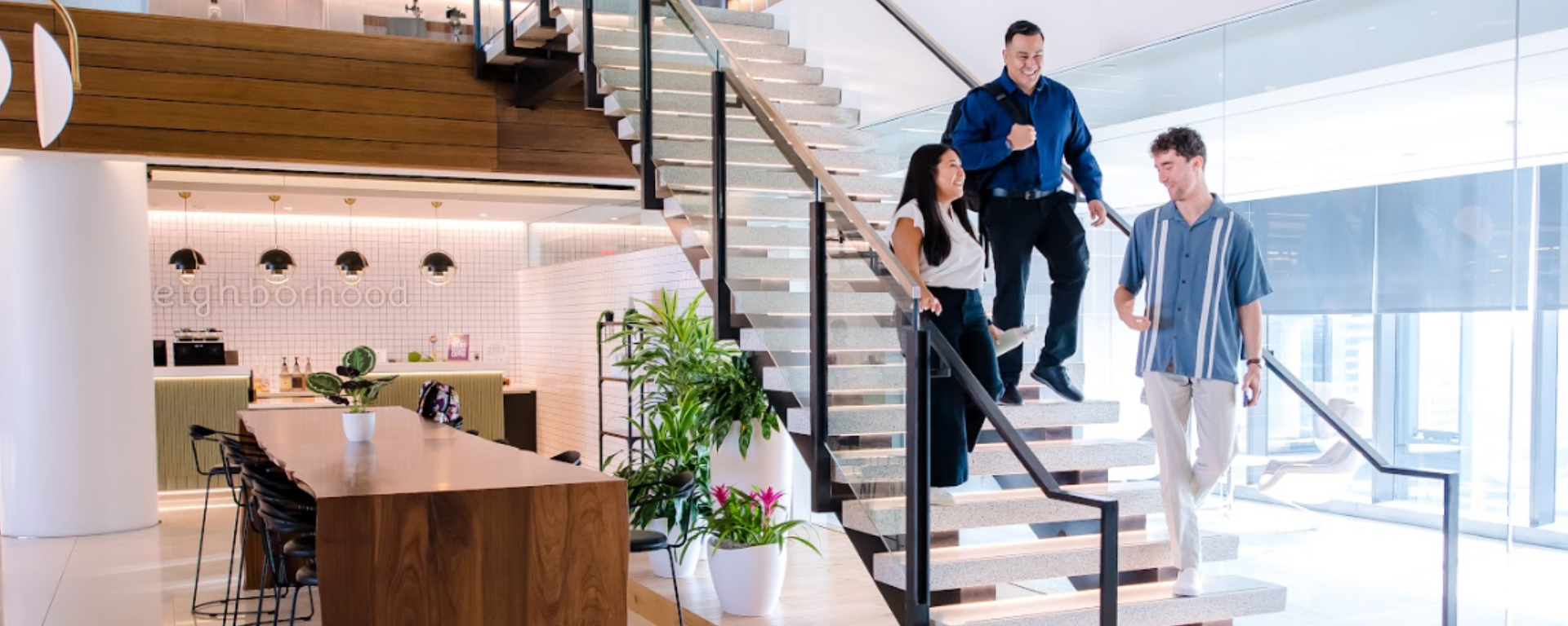 Three Capital One associates talk and walk down the stairs together