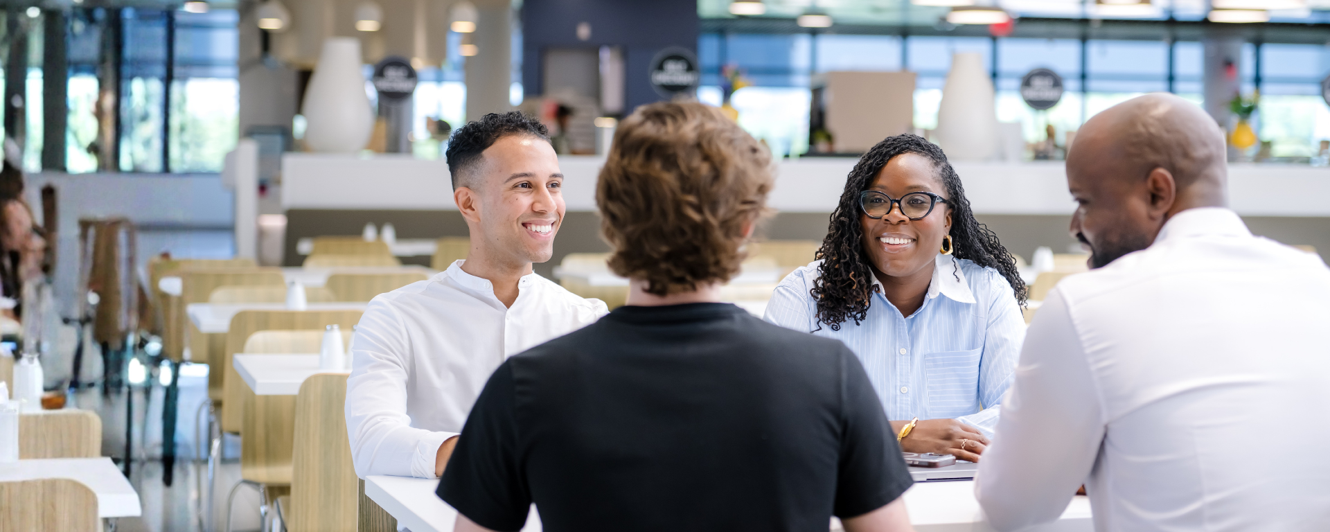 Capital One associates sit at a high top table and laugh together