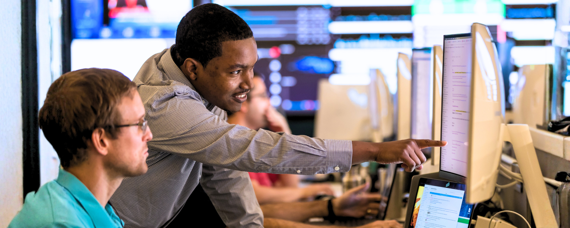 Capital One associate pointing to peer's monitor