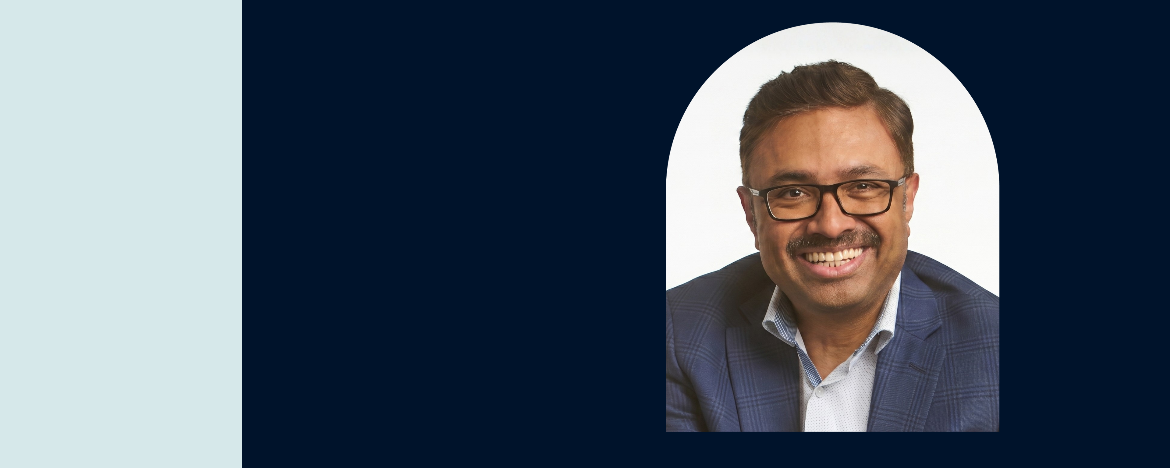 Headshot of Capital One associate Prem Natarajan smiling in a dark blue suit