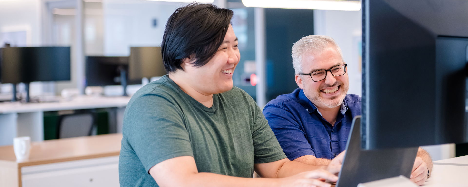 Capital One associates working together on laptop and monitor