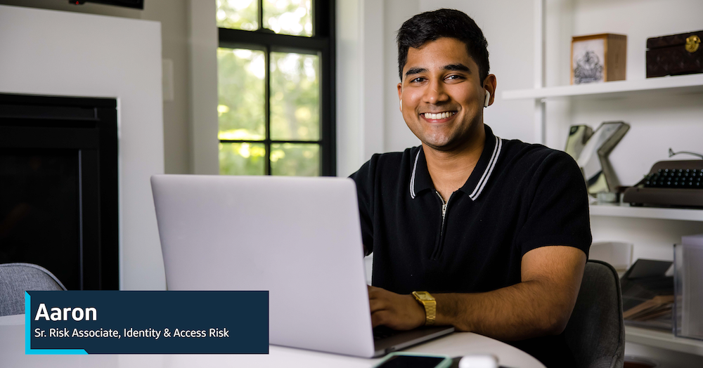 Aaron, Capital One Sr. Risk Associate, Identity & Access Risk, sits at his laptop at home
