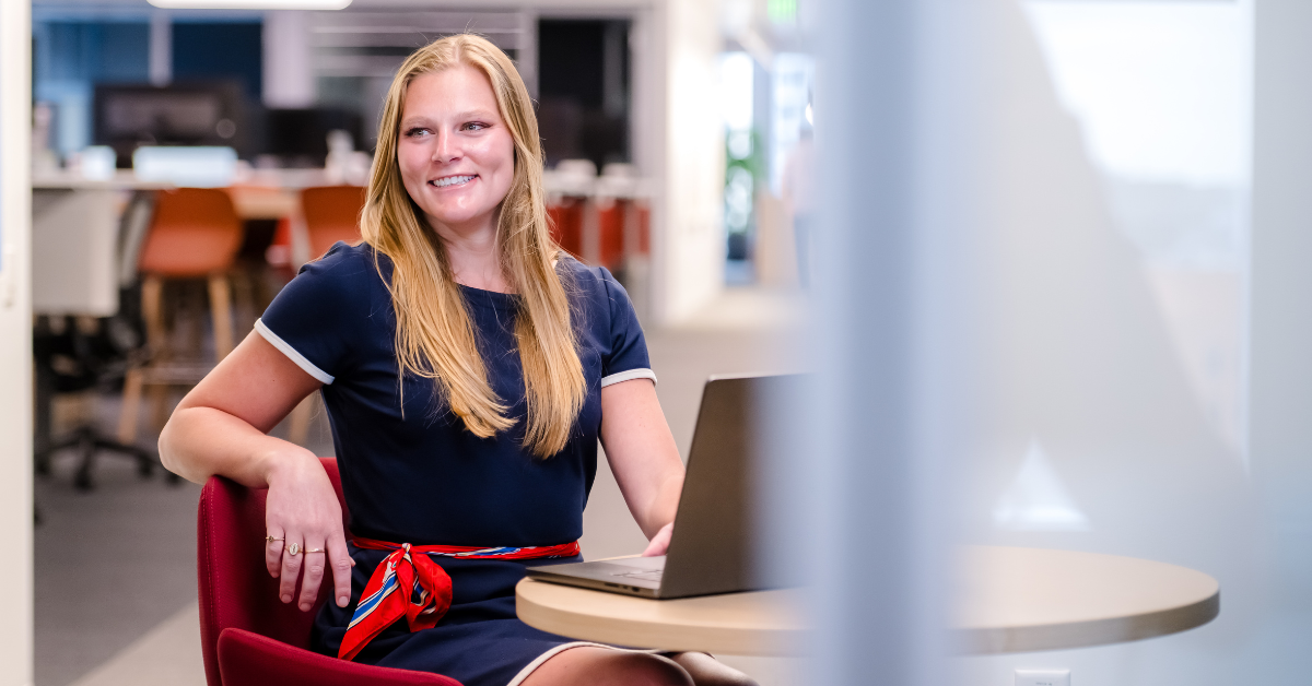Capital One associate smiling in red chair with laptop open
