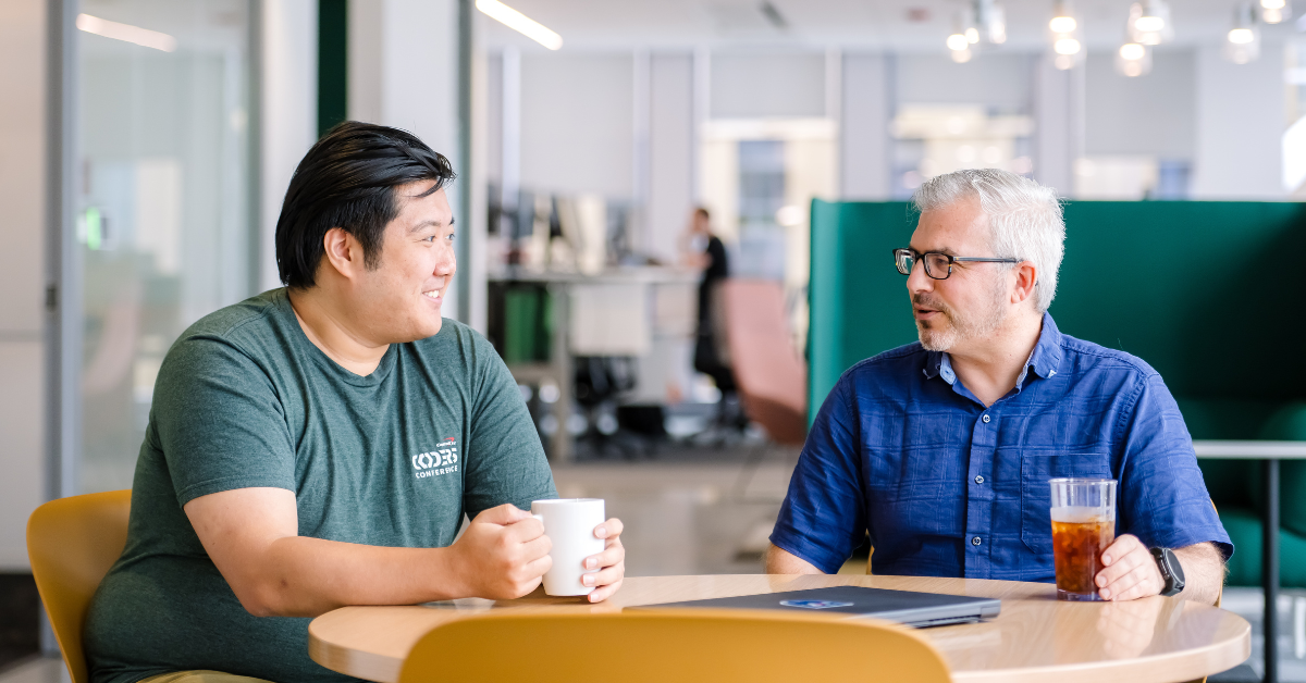 Two Capital One associates chatting with coffee