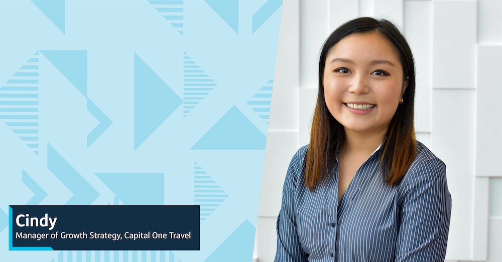 Capital One associate Cindy stands in front of a white wall wearing a blue striped shirt