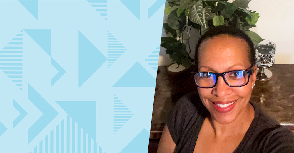 Dorothy, Capital One Project Manager, Global Workspace Solutions, in front of a plant, the picture next to a blue two-toned triangular background