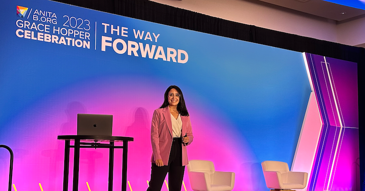Fatma, Capital One associate, stands on the Grace Hopper stage and speaks