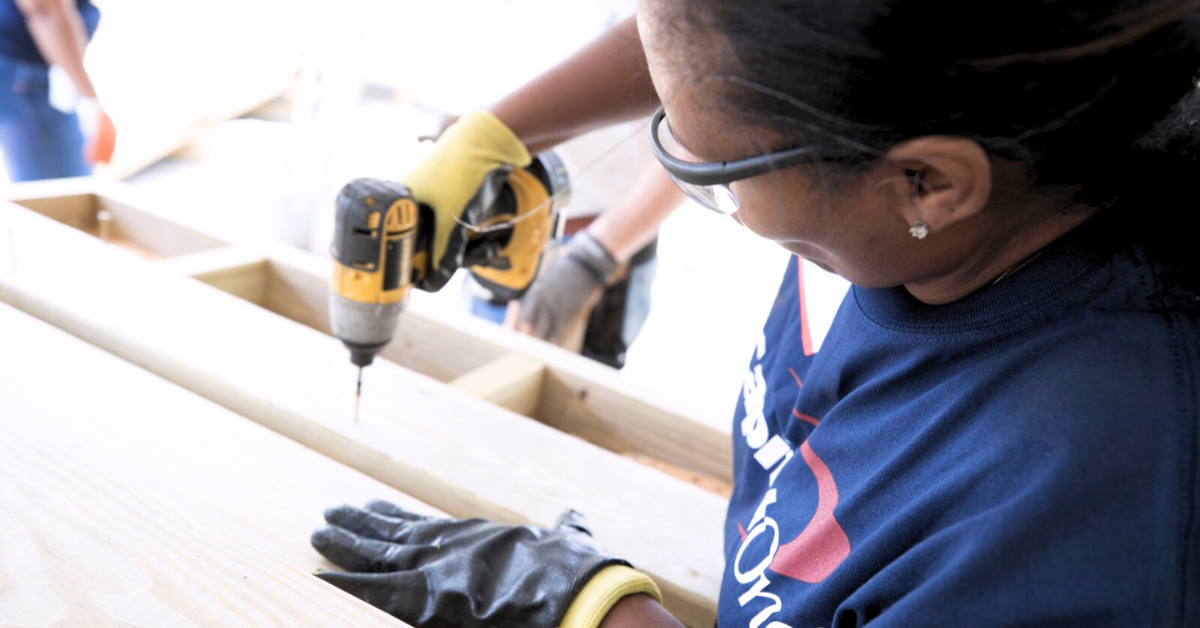 A Capital One associate drills into wood, giving back to her community