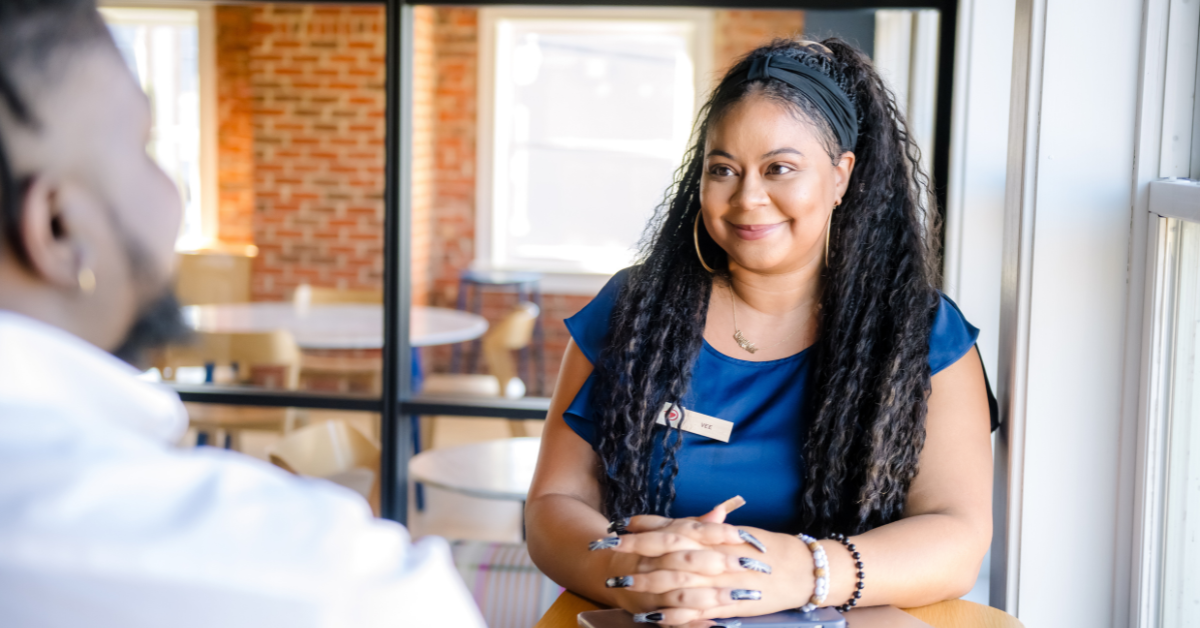 A Capital One associate stands and talks to a customer