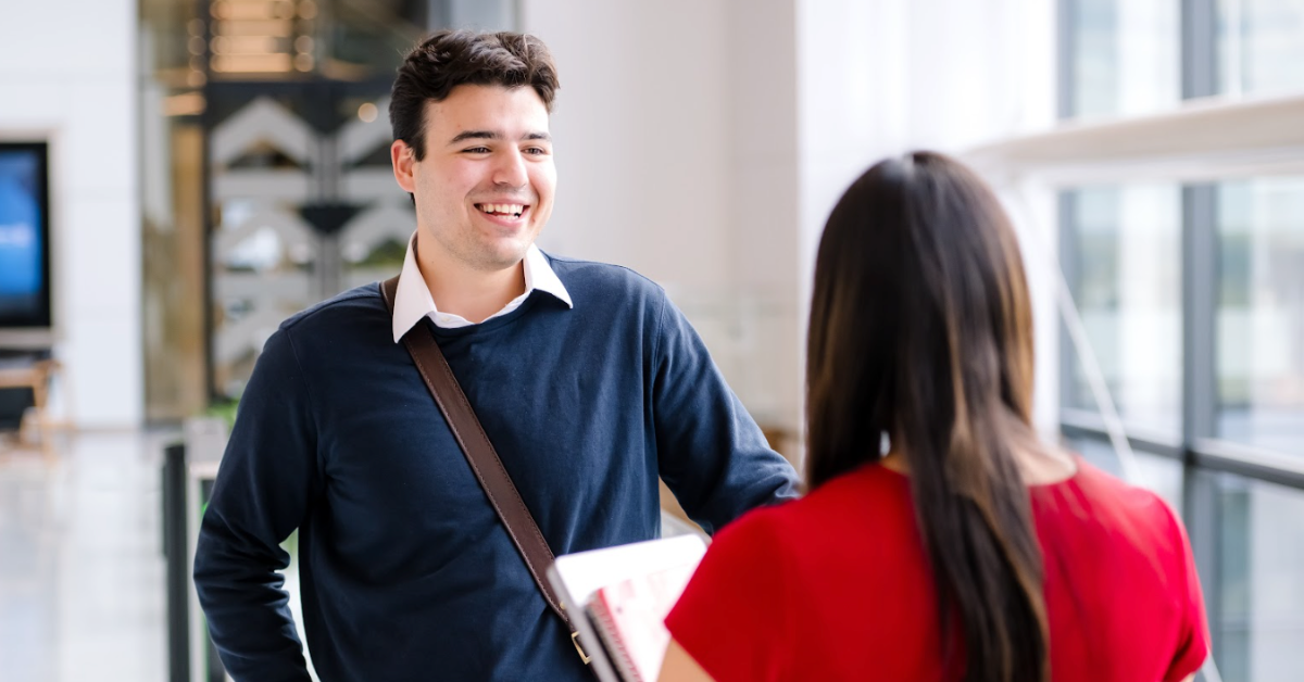 Two Capital One associates stand by a window and talk