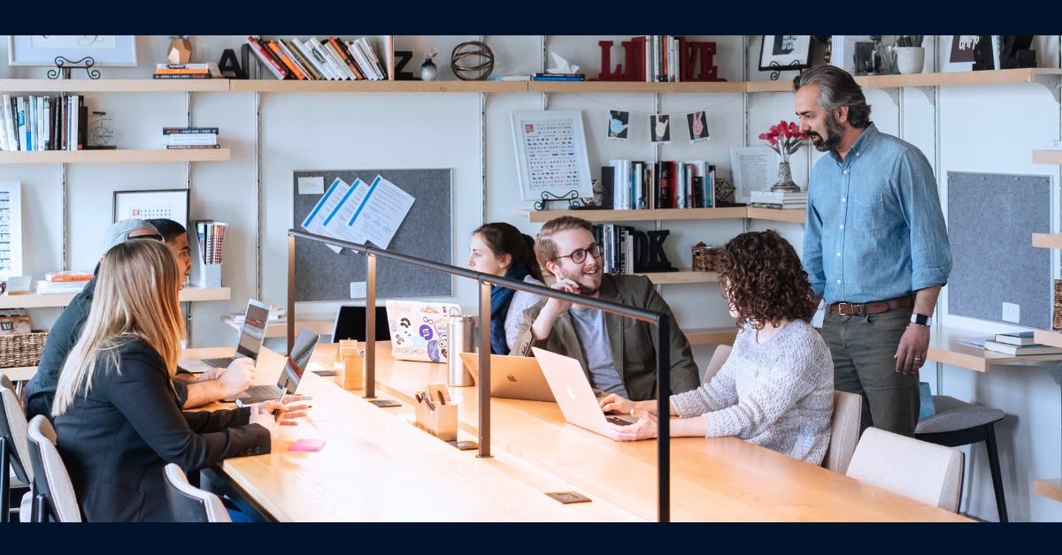 Associates sitting around a table and talking while working together