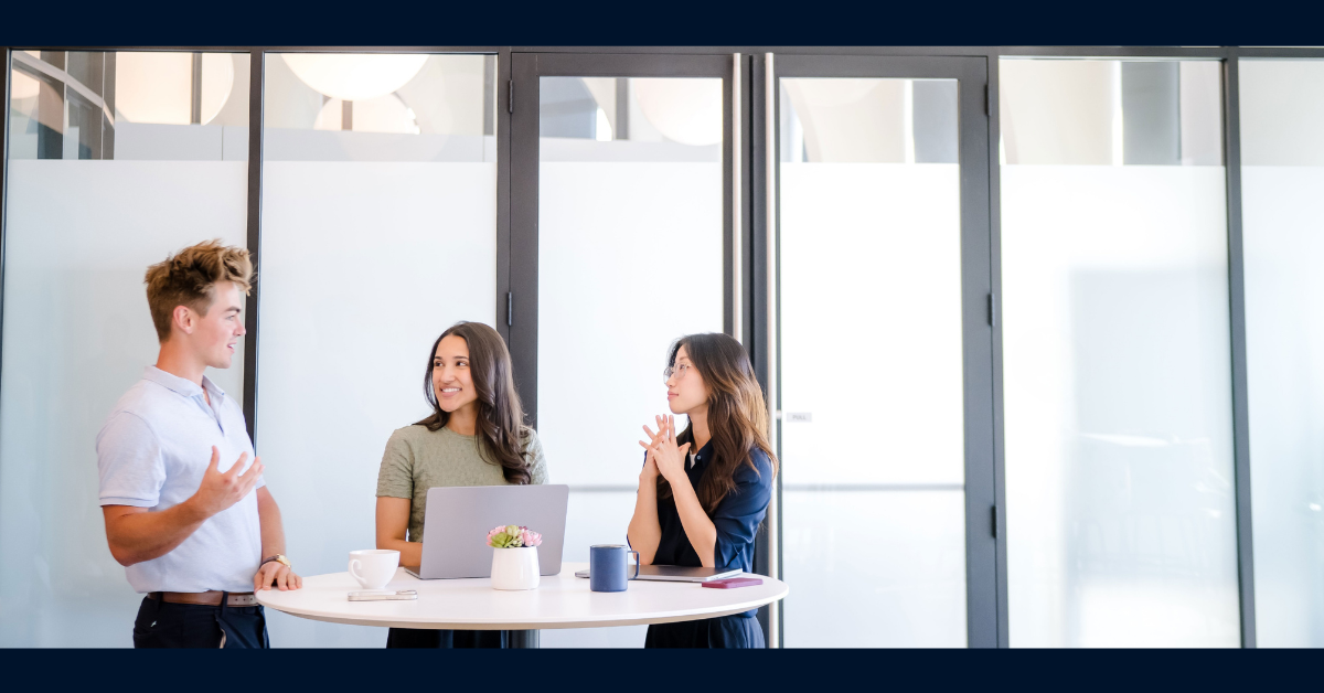 Three Capital One associates talk around a round table
