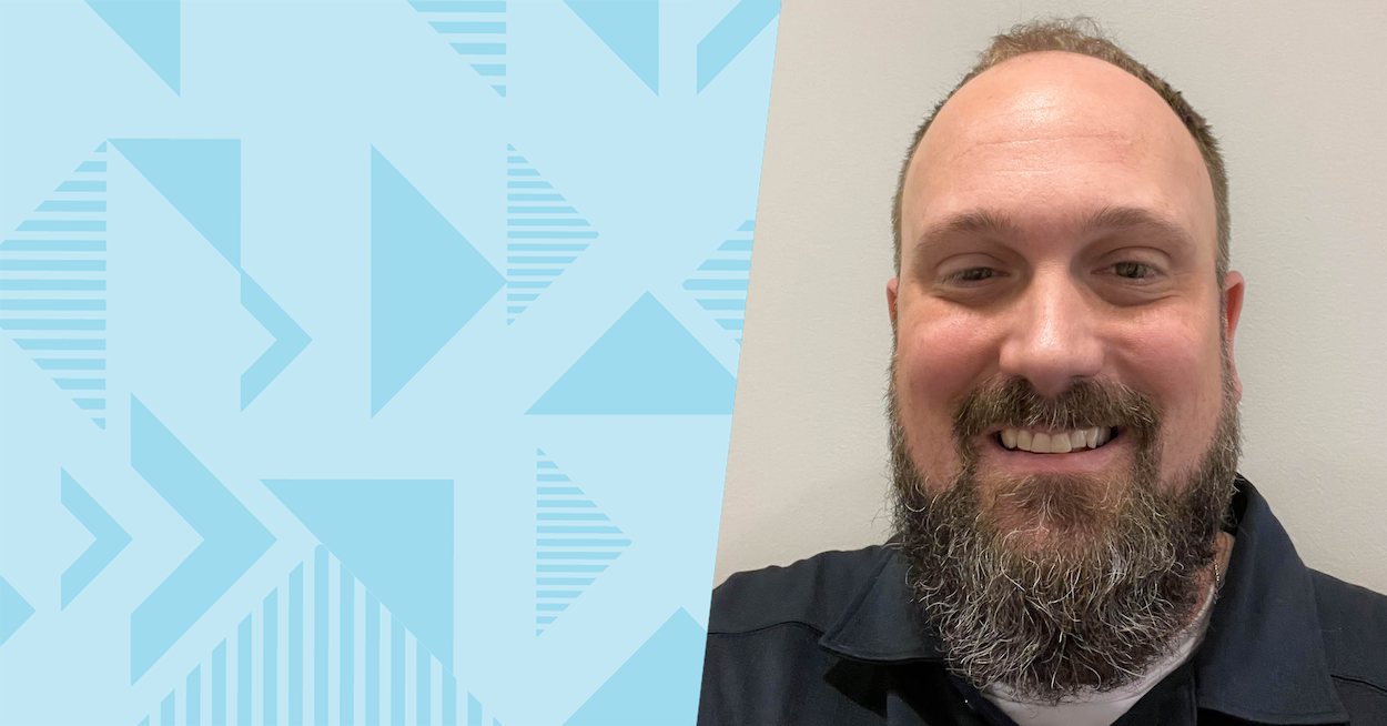 Jason P., Capital One Business Execution Lead, Supplier Partner Operations, smiles in front of a white wall, next to a blue two-toned triangular background