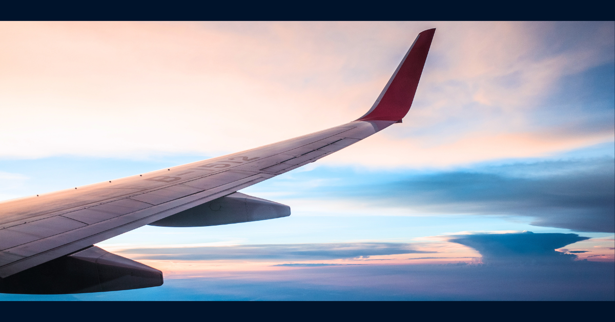 Plane flying through the clouds during sunset