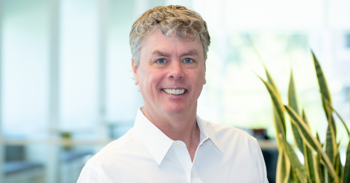 Capital One associate stands and smiles in a white shirt