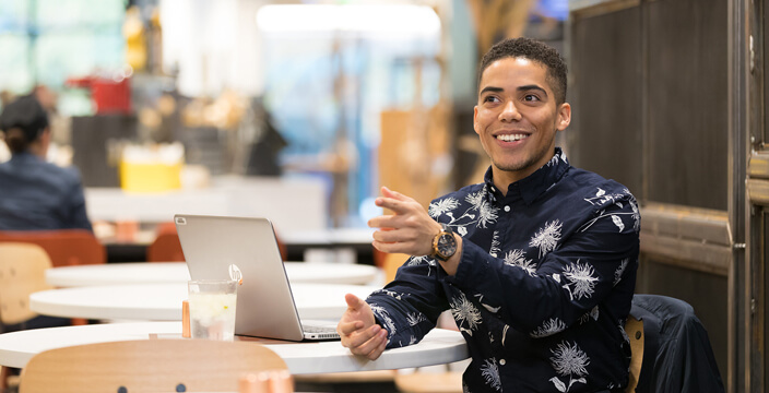 Man in an office environment, mid-conversation