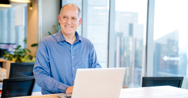 Capital One associate standing at desk and working on laptop