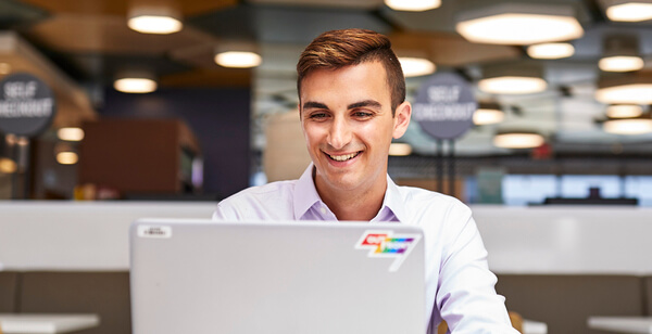 Smiling young man working at laptop