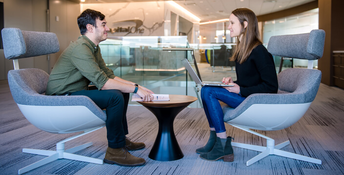 Two coworkers talk at a small cafe table