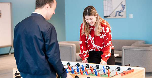 Two Capital One Strategy Consulting associates play foosball