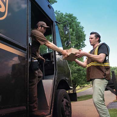 Employees delivering packages from a delivery truck.