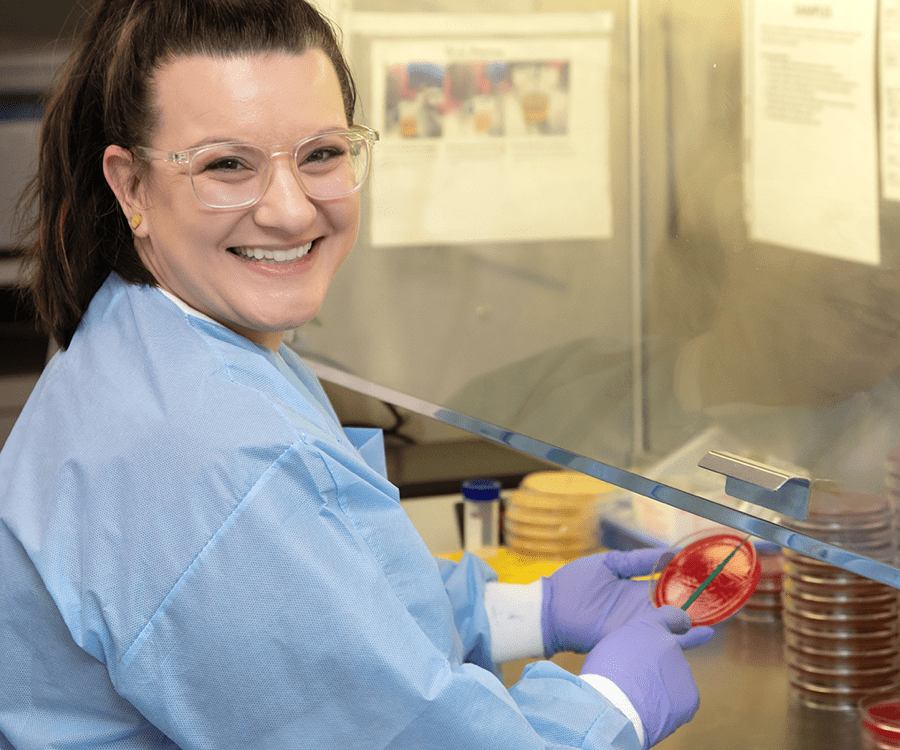 Smiling med tech holding a petri dish