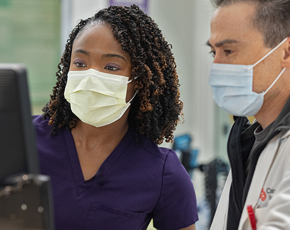 Female and Male medical professionals looking at a monitor