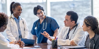Group of doctors together for a group photo at a table