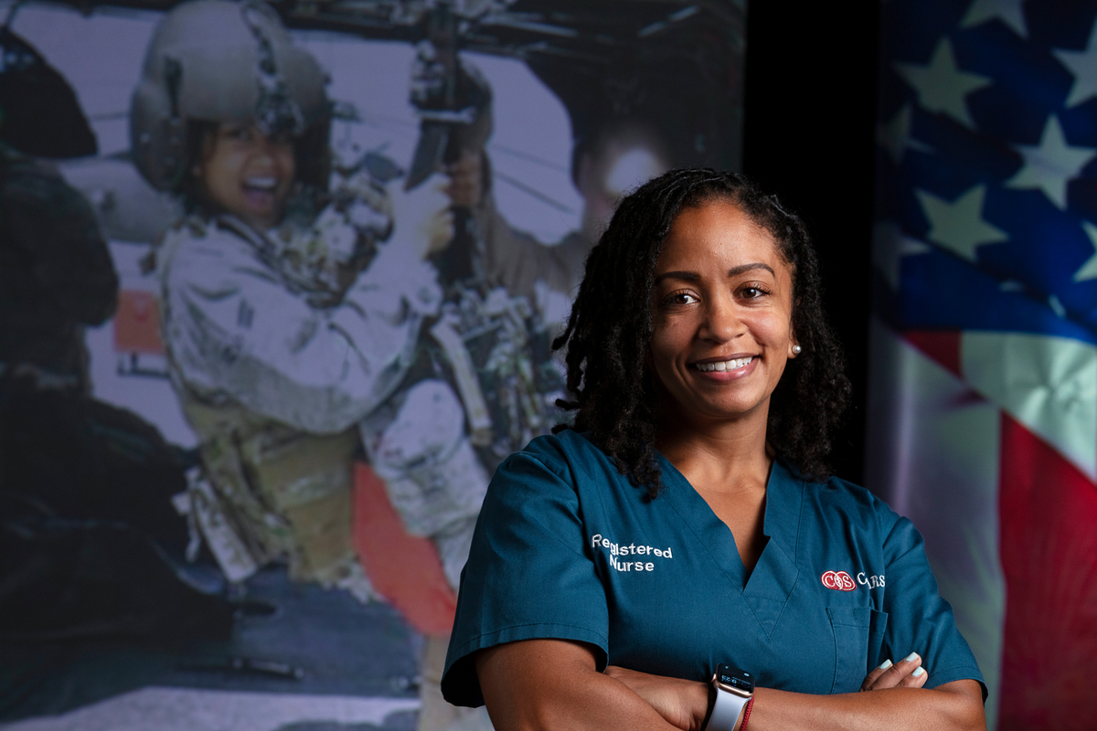 Nurse smiling in front of her military picture