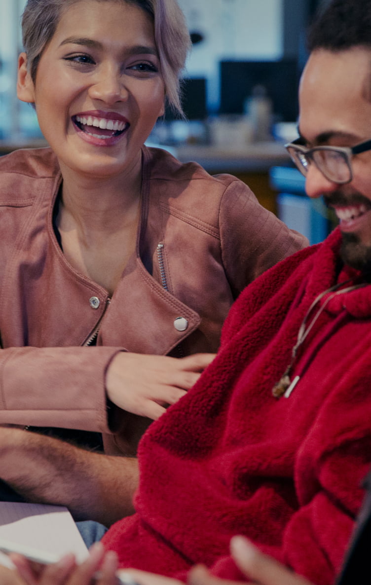 People sitting together and smiling while in an office setting.