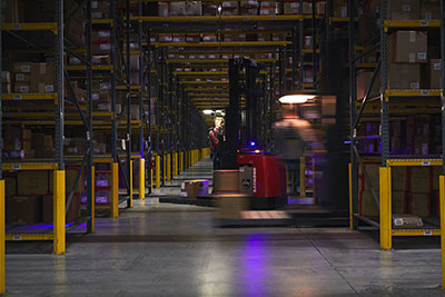 forklift in aisle of warehouse