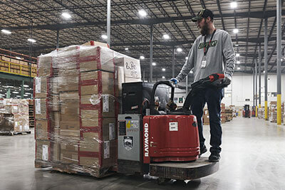 man driving forklift with packages