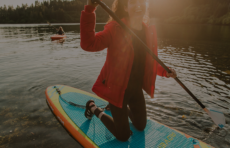 A woman paddleboards on a lake