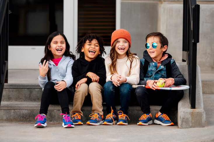 Kids sitting on a step laughing