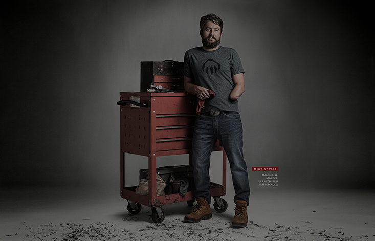 A man missing his left hand poses confidently next to a cart of tools