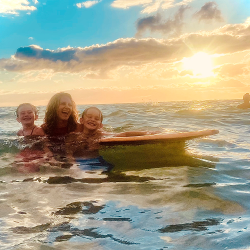 woman with her sons in the ocean