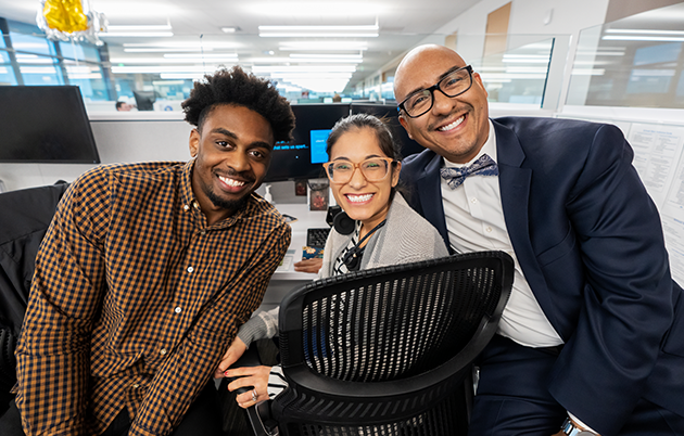 Three employees sitting at a desk