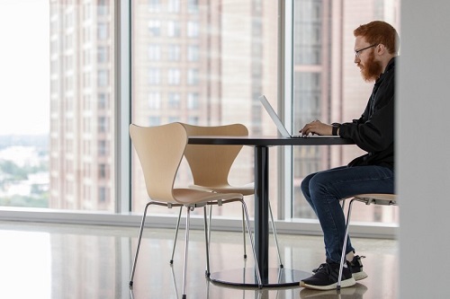 Schwab Man Building Resume on Laptop