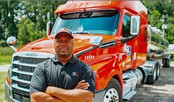 Man standing in front of a Big red Truck