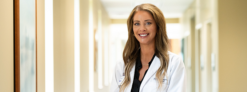 Sarah Latoria, MSN, APRN, poses for a photo in a white coat.   