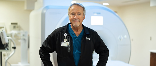 Portrait of James Fulara in front of an MRI machine.