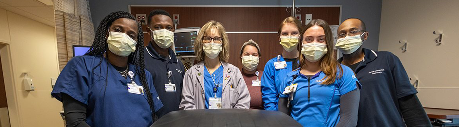 A group of Northwestern Medicine staff pose behind a recycling bin labeled, “IV Bag Recycling.”