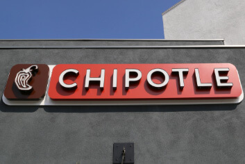 Chipotle restaurant sign on the outside of the restaurant on a sunny day.