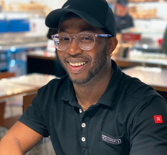 Chipotle Crew member smiles while sitting in the restaurant