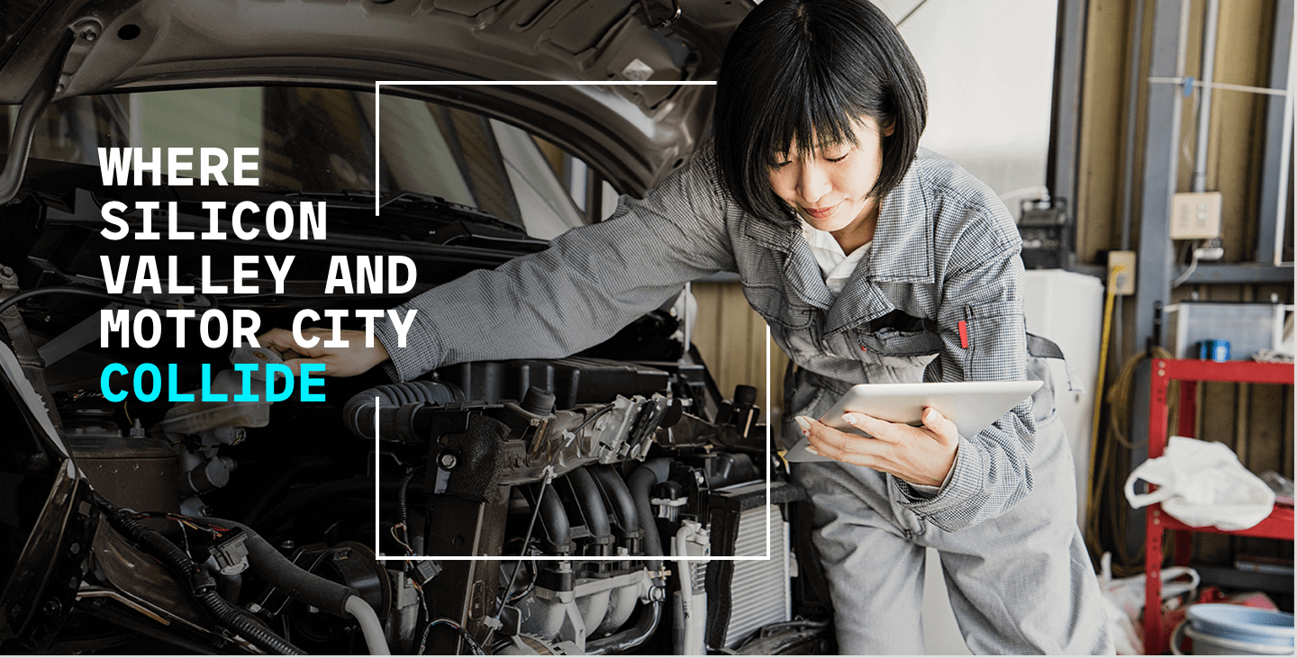 Female mechanic fixing a car while staring at her Ipad.